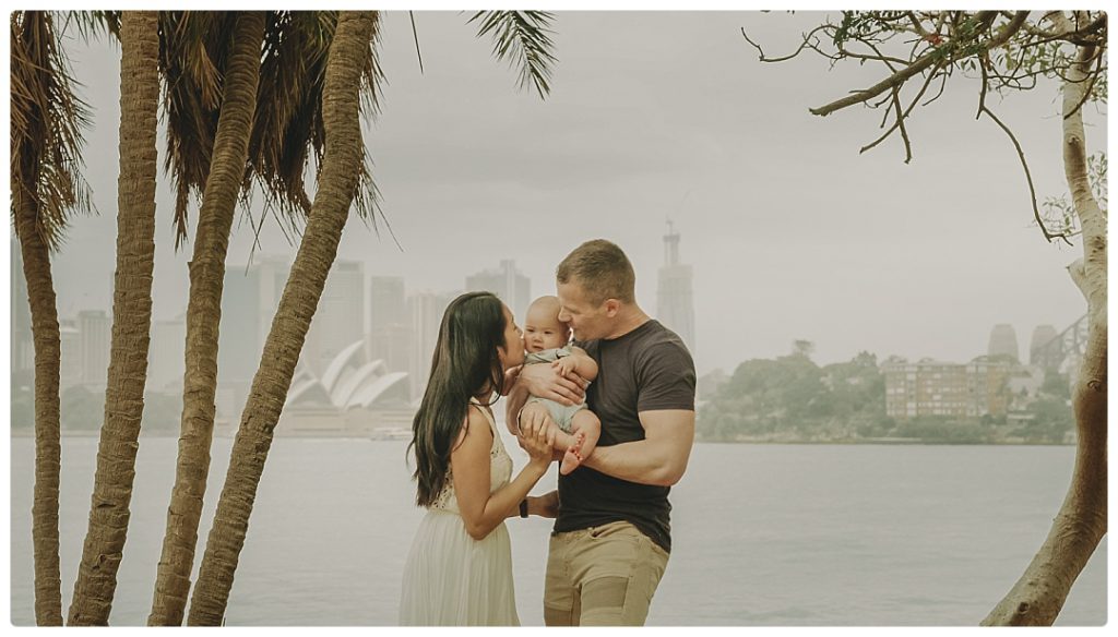 mother-and-father-kiss-the-child-sydney-photographer-photo