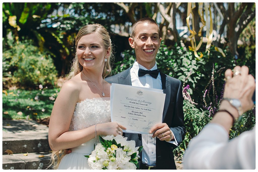 husband-and-white-holds-their-wedding-certificate-after-the-ceremony-photo